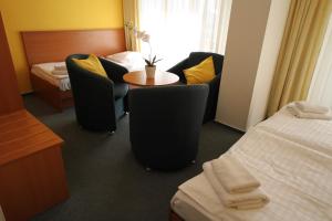 
a room with a couch, chair, table and a lamp at Hotel Meritum in Prague
