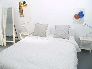 a white bed with two pillows on top of it at Newly Renovated Apt in Kolonaki in Athens