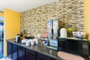 a kitchen with a counter with a microwave at Super 8 by Wyndham Perry IA in Perry