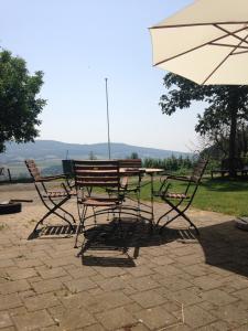 una mesa, sillas y una sombrilla en el patio en BnB im Waldhof, en Schneisingen