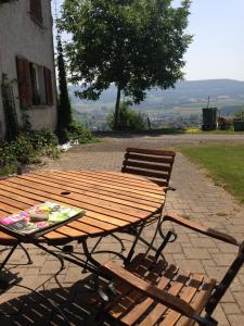 una mesa de picnic de madera y un banco en un patio en BnB im Waldhof, en Schneisingen