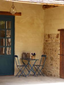 a table and two chairs in a room with a door at La Rosière in Auzelles