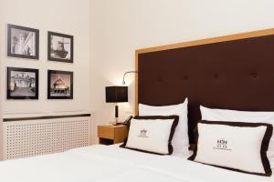 sypialnia z dużym białym łóżkiem z 2 poduszkami w obiekcie Hotel Brandenburger Tor Potsdam w Poczdamie