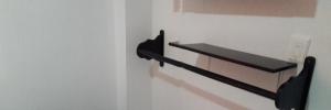 a black cat shelf on a white wall at Hotel Torres del Parque No3 in Barranquilla