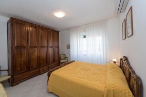 フィナーレ・リーグレにあるDomitilla Houseのベッドルーム1室(ベッド1台付)、木製キャビネットが備わります。