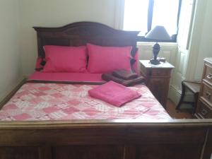 een slaapkamer met een bed met roze kussens bij Casa da Carlota in São Vicente de Pereira Jusã
