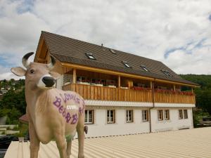 Una estatua de una vaca parada frente a un edificio. en Conny's B&B, en Niederweningen