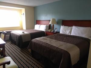 a hotel room with two beds and a window at Expo Inn in Tulsa