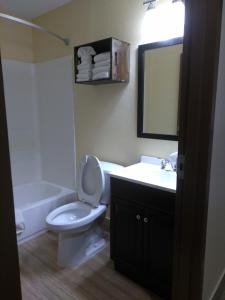 a bathroom with a toilet and a sink and a mirror at Expo Inn in Tulsa