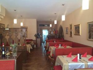 restauracja ze stołami i krzesłami z czerwonymi serwetkami w obiekcie Weinstube Heigl Restaurante Pizzeria Puccini w mieście Landshut