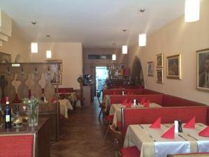 ランツフートにあるWeinstube Heigl Restaurante Pizzeria Pucciniのテーブルと椅子と赤いナプキンを用意したレストラン