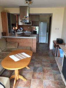 a kitchen and living room with a wooden table at Davidkov Holiday Home in Shipka