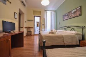 a bedroom with two beds and a flat screen tv at Palazzo Santori in Tivoli