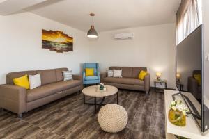 a living room with two couches and a tv at Villa Rusula in Kastel Novi