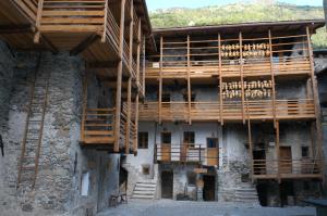 - un bâtiment avec des balcons en bois sur le côté dans l'établissement Contrada Beltramelli, à Villa di Tirano