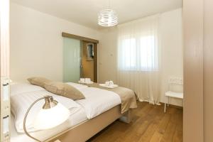 a white bedroom with a large bed and a lamp at Villa Rusula in Kastel Novi +106 photos