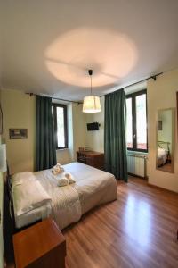 a bedroom with a large bed with green curtains at Palazzo Santori in Tivoli