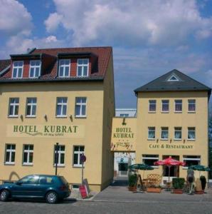 ein blaues Auto, das vor einem Hotel Kirmit parkt in der Unterkunft Hotel Kubrat an der Spree in Berlin