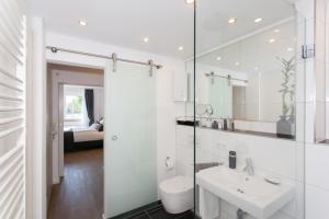 a white bathroom with a sink and a toilet at Main Apartment Frankfurt Offenbach in Offenbach +16 photos