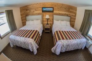 Un pat sau paturi într-o cameră la Stagecoach Inn & Suites