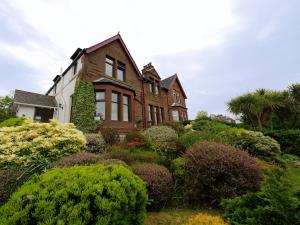 una casa con un montón de arbustos delante de ella en Belvedere, en Brodick