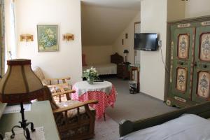 a living room with a table and a tv at Hotel Haus Kirsch in Grevenbroich