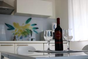 a bottle of wine and two wine glasses on a table at Sweet Apartments in Split