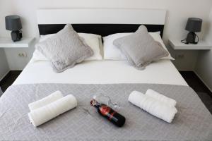 Elle comprend un grand lit blanc avec deux oreillers et une lampe de poche rouge. dans l'établissement Sweet Apartments, à Split