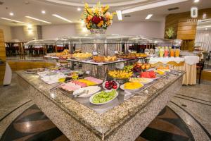 uma linha de buffet com muitos tipos diferentes de alimentos em Scorial Rio Hotel no Rio de Janeiro