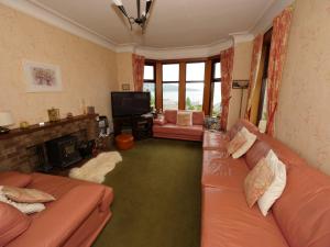 a living room with two leather couches and a television at Belvedere in Brodick