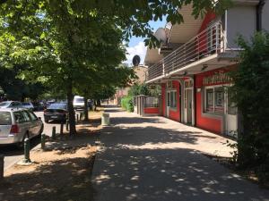 a sidewalk next to a building with cars parked on the street at Apartments Premović Nikšić in Nikšić