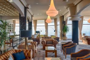 a lobby with couches and chairs in a building at Mercure Monte Igueldo in San Sebastián