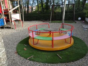 einen Spielplatz mit einem Tisch und einer Schaukel in der Unterkunft Vue sur mer et montagnes in Moriani Plage