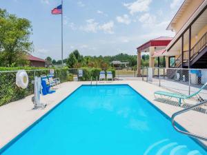 a large swimming pool with chairs and a flag at Super 8 by Wyndham Cleveland in Cleveland