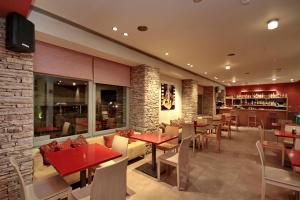 a restaurant with tables and chairs and a bar at Astros Beach Boutique Hotel in Paralion astros