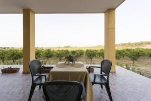 a dining room with a table and chairs on a porch at Agriturismo Il Giriatello in Crotone