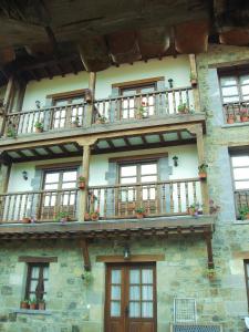 un edificio de piedra con ventanas y balcones. en Casa Rural Josefina, en Aliezo