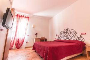 a bedroom with a red bed with a red blanket at Pinguino B&B in Scala