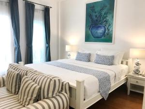 - une chambre avec un grand lit blanc et 2 chaises dans l'établissement Casa Blanca Boutique Hotel - SHA Plus, à Phuket