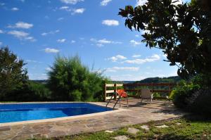 a swimming pool with two chairs next to a house at Chez Lucien in Trébas