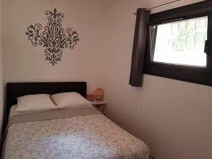 1 dormitorio con cama y ventana en B&B Les Grillons, en Draguignan