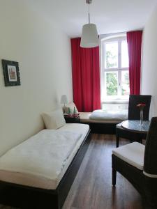 Zimmer mit 2 Betten und einem Fenster mit roten Vorhängen in der Unterkunft Apartment KiezFlair in Potsdam