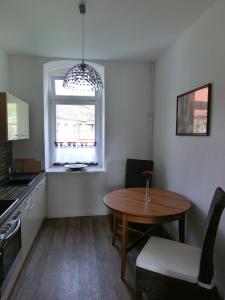 uma pequena cozinha com uma mesa e uma janela em Apartment KiezFlair em Potsdam
