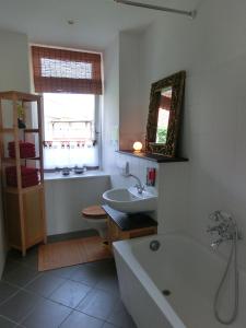 a bathroom with a bath tub and a sink at Apartment KiezFlair in Potsdam