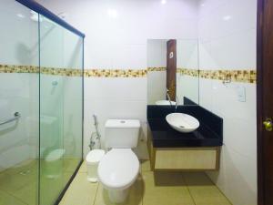 a bathroom with a toilet a sink and a bath tub at Pousada Aconchego in Pitimbu