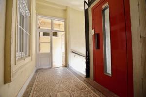 ブダペストにあるLuxury Apartment by Hi5 - Szervita Suiteの赤いドアと窓が空の廊下