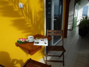 een tafel met een kopje koffie en een kom bloemen erop bij kasa Tambla in Ponta do Sol