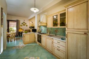 a kitchen with wooden cabinets and a dining room at Appartamenti il Patio in San Vito lo Capo