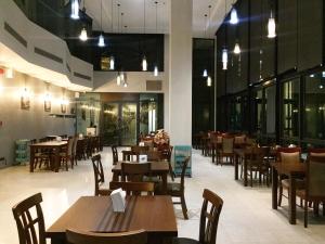 ein Restaurant mit Holztischen und -stühlen und Lichtern in der Unterkunft The Museum Hotel in Nakhon Pathom