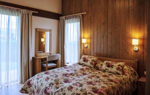 a bedroom with a bed with a floral bedspread at Golf Villa Malina in Bansko